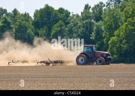Tractor in dry dusty farm field Stock Photo