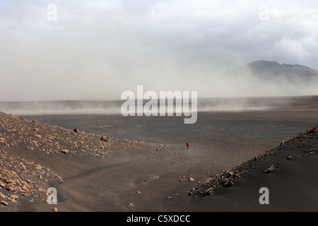 Hikers in the Emstrur Area of the Laugavegur (Laugavegurinn) Hiking Trail With Volcanic Dust Storm Behind, Iceland Stock Photo