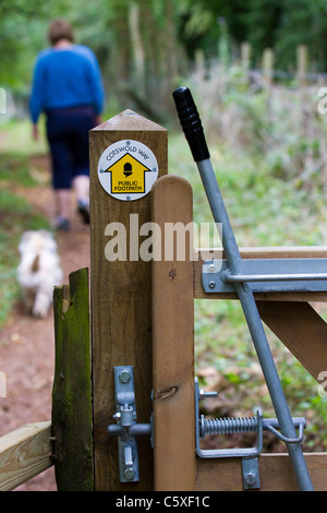 A woman and dog walking along the Cotswold Way in Gloucestershire Stock Photo