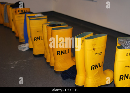 Lifeboat mens boots ready for action in Shoreham Lifeboat station. West Sussex. England. Stock Photo