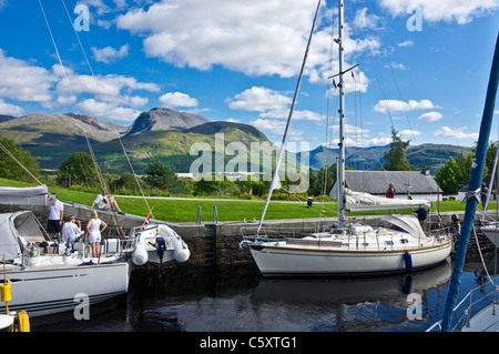 Yachts moving north through the locks on the Caledonian Canal at Banavie near Fort William in Scotland with Ben Nevis behind Stock Photo