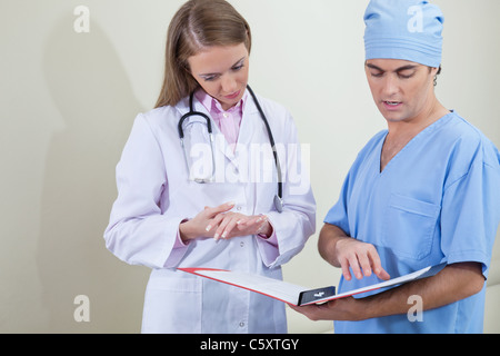 Doctor and nurse reading information from file folder Stock Photo