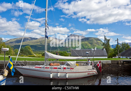 Yachts moving north through the locks on the Caledonian Canal at Banavie near Fort William in Scotland with Ben Nevis behind Stock Photo