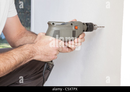 Close-up of human hand holding drilling machine Stock Photo