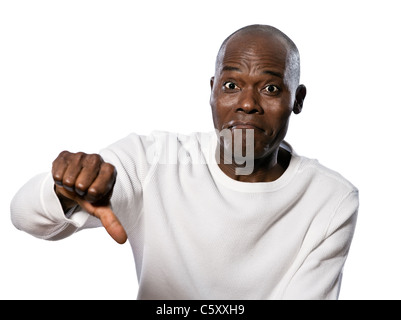 Portrait of a displeased afro American man showing thumbs down sign in studio on white isolated background Stock Photo