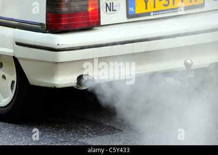 Close up Dutch registered old Citroen car with defective polluting exhaust system fumes damaging environment driving on road Park Lane London UK Stock Photo