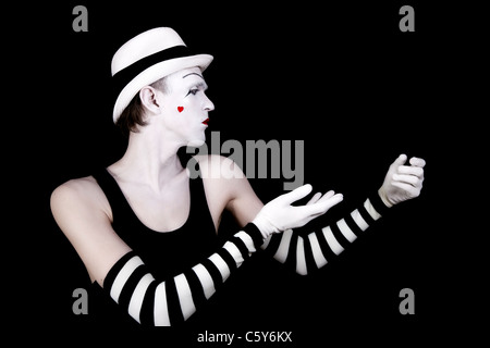 dancing mime in white hat with heart on her cheek on black background Stock Photo