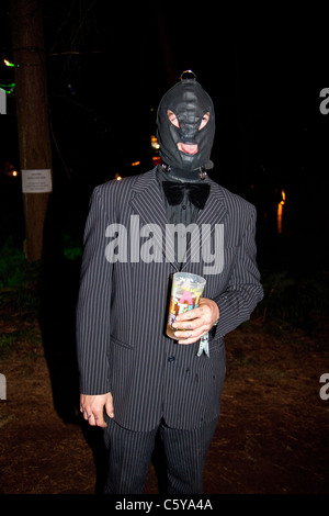Man in a suit wearing a gimp mask at the Latitude Festival 2011, Suffolk, England, United Kingdom. Stock Photo