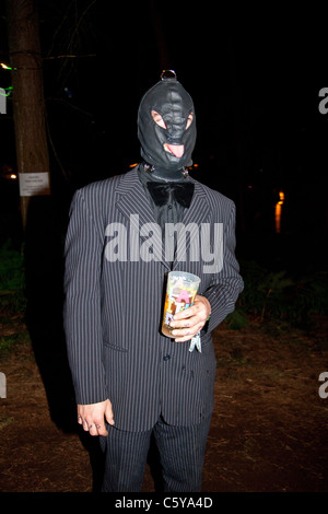 Man in a suit wearing a gimp mask at the Latitude Festival 2011, Suffolk, England, United Kingdom. Stock Photo