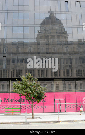 The Port of Liverpool building reflected in mirrored glass in a modern new office block built as part of the city's regeneration Stock Photo
