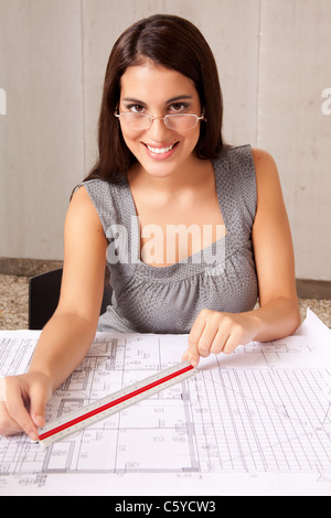An architecture checking measurements on a set of blueprints Stock Photo