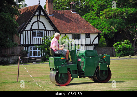 Man rolling cricket pitch on The Green, Bearsted, Maidstone District, Kent, England, United Kingdom