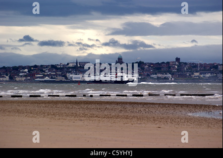 Isle of Man ferry in the River Mersey seen from Crosby Beach with Birkenhead in the background in a gathering storm Stock Photo