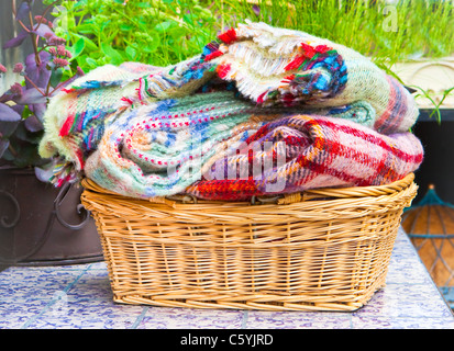 Lovely soft woolen blankets in a basket in the garden Stock Photo