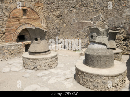 Bakery, Pompeii. In  foreground are millstones that were turned by mules. In back is the wood burning oven. Stock Photo