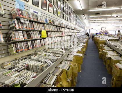 Used DVDs, CDs, and vinyl records line the walls and shelves in a music store Stock Photo