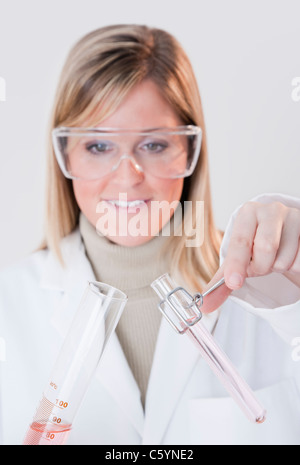 USA, Illinois, Metamora, close up of woman with protective glasses holding laboratory glassware Stock Photo