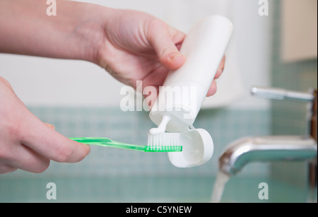 Female hand holding toothbrush with toothpaste isolated on white ...