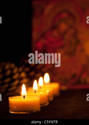 USA California, Fairfax, row of candles, defocused icon with Virgin Mary and Jesus in background Stock Photo