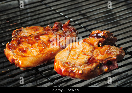 Two bbq pork chops finishing on the grill Stock Photo