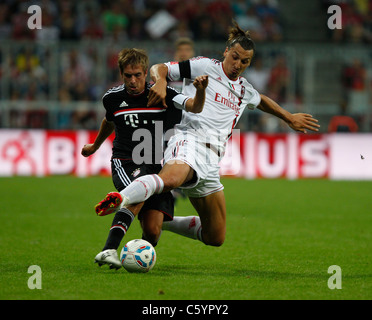 FC Bayern player Philipp Lahm (left) and AC Milan player Zlatan Ibrahimovic  in action Stock Photo