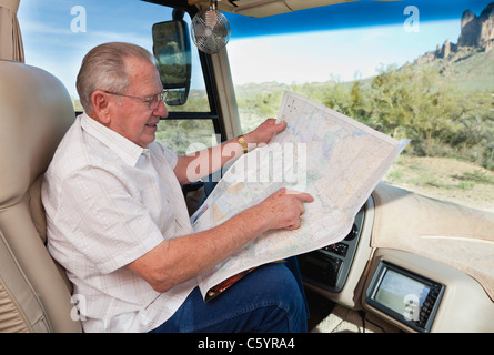 USA, Arizona, senior man in car reading map Stock Photo