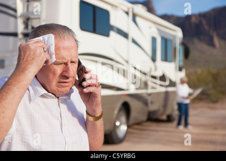 USA, Arizona, senior man standing in front of mobile home talking on mobile phone Stock Photo