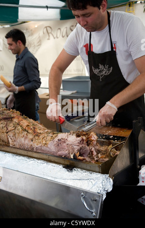 Man carving hog on spitroast at Southbank food festival Stock Photo