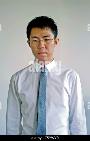 Portrait young Asian Businessman Looking down, in Medium Shot, Glasses Front Stock Photo