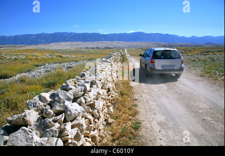 Sandy road from the main road leading to the beach called Zrće on the island of Pag and car is heading in direction of a beach. Stock Photo