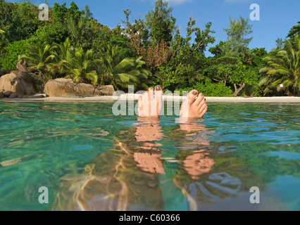 Womens feet, split level, Anse Lazio, Baie Sainte Anne district, Island of Praslin, Seychelles, Indian Ocean, Africa Stock Photo