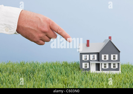 Close up of man's hand pointing on model house Stock Photo