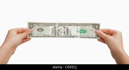 USA, Illinois, Metamora, Studio shot of woman's hands stretching US dollar banknote Stock Photo