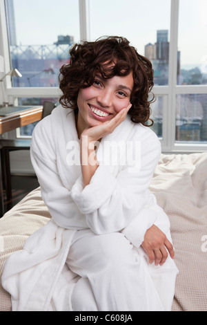 USA, New York City, portrait of woman sitting on bed Stock Photo