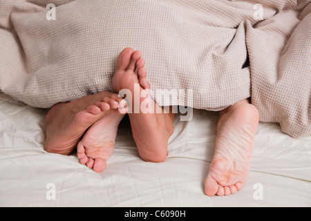 USA, New York City, feet of couple sleeping in bed Stock Photo