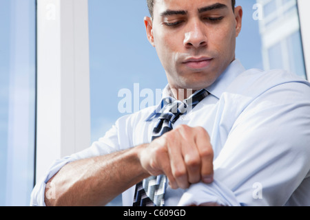 USA, New York State, New York City, business man adjusting shirt by window Stock Photo