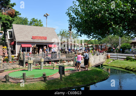 Tourists playing minigolf on a sunny clear summer day at Pirates Cove in Yarmouth, Cape Cod Massachusetts USA Stock Photo