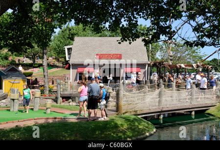 Tourists playing mini-golf on a sunny clear summer day at Pirates Cove in  Yarmouth, Cape Cod Massachusetts USA Stock Photo