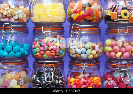 Colourful childrens sweets in kilner jars. Liquorice allsorts, Smarties, pineapple cubes, humbugs, bonbons, dolly mixtures, jelly beans and mini eggs Stock Photo