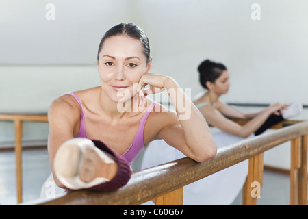 Ballet dancers stretching at barre Stock Photo