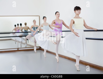 Ballet dancers posing at barre Stock Photo