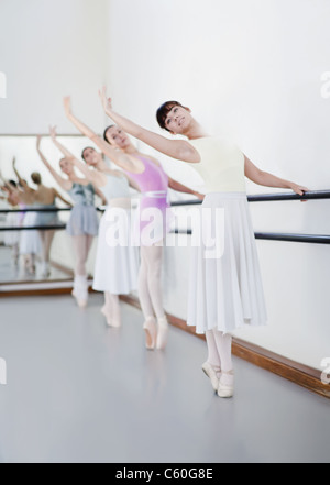 Ballet dancers posing at barre Stock Photo
