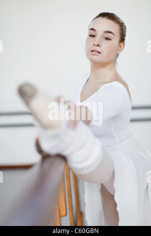 Ballet dancer stretching at barre Stock Photo