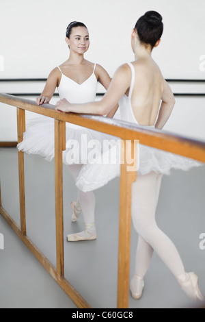 Ballet dancers posing at barre Stock Photo