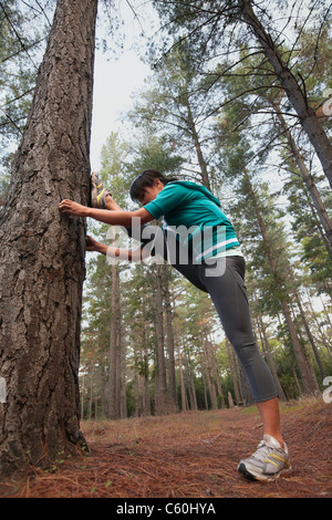 Runner stretching in forest Stock Photo
