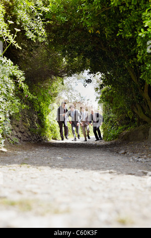 Businessmen running on rural road Stock Photo