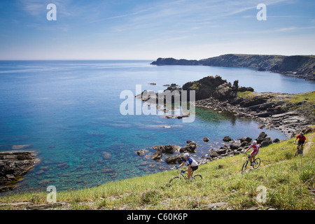 Mountain bikers riding on coastline Stock Photo