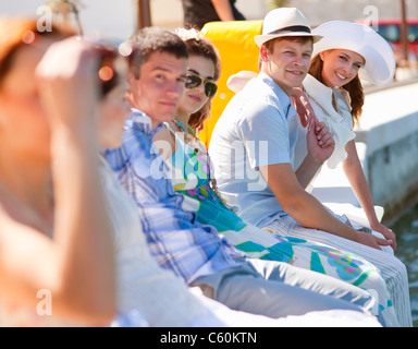 Friends sitting on urban dock Stock Photo