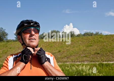 Older man fastening bike helmet Stock Photo