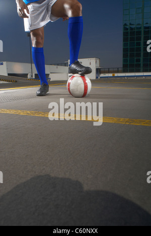 Soccer player with ball on rooftop Stock Photo